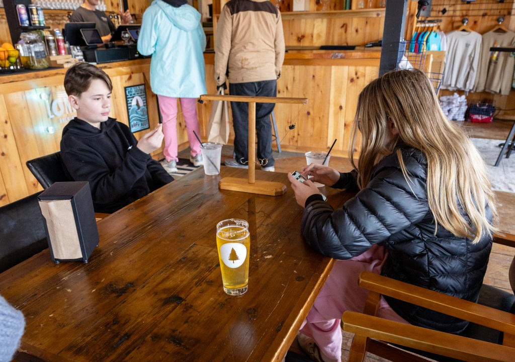 Kids sitting at table playing a game inside brewery
