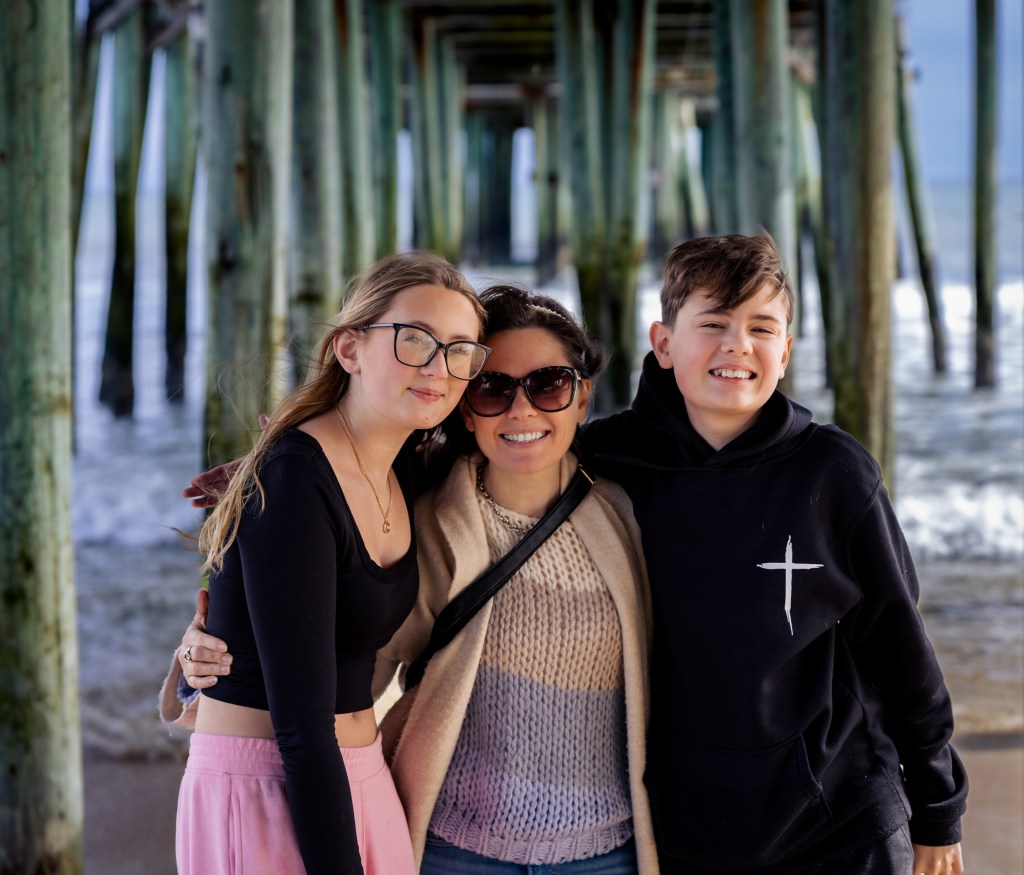 Portrait under the pier with wooden beams and ocean background