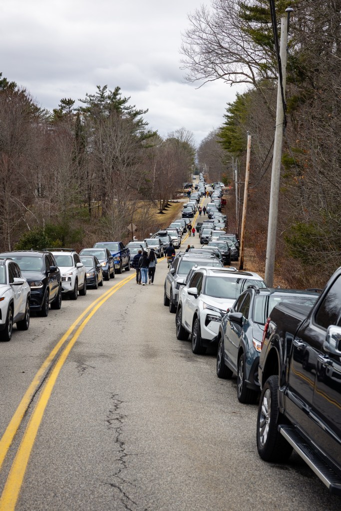 Crowded road with parked cars and people leaving Merrifield Farm