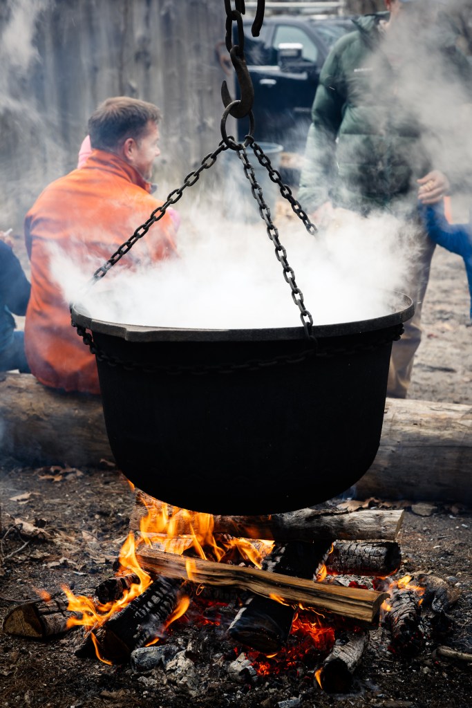 Large pot of maple syrup boiling over an open fire at Merrifield Farm