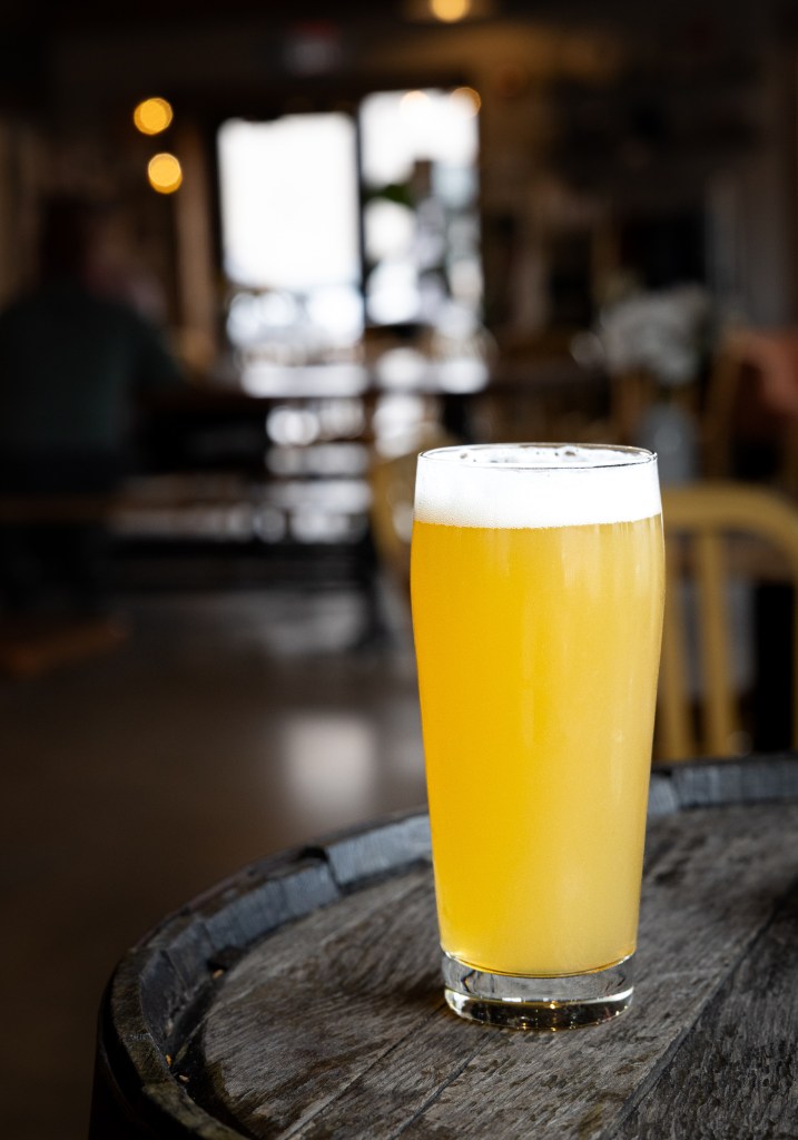 Hazy New England IPA on wooden barrel table