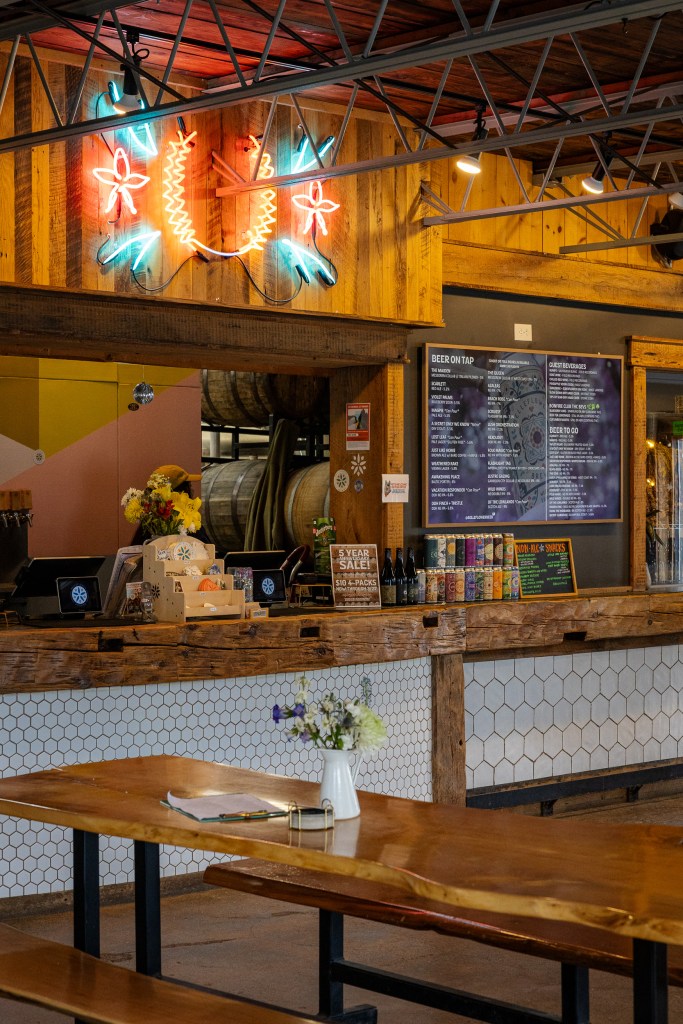 Bar area with neon sign and tap list