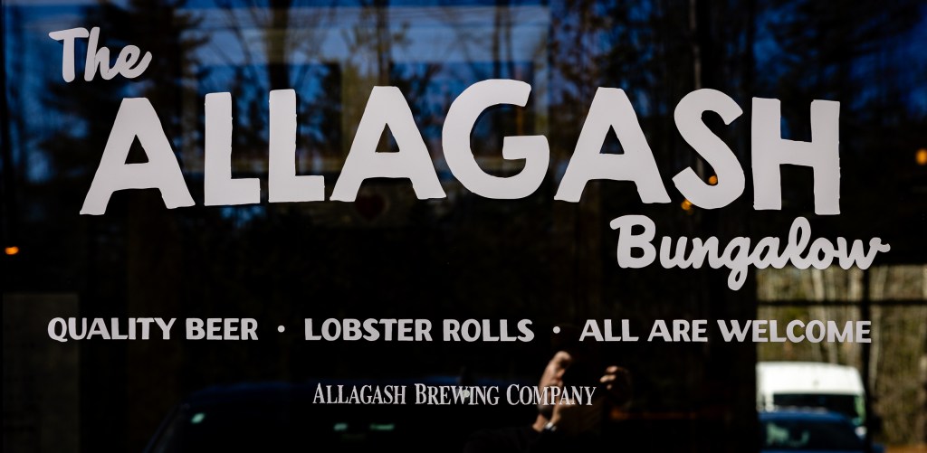 Close-up of Allagash Bungalow window lettering and branding detail
